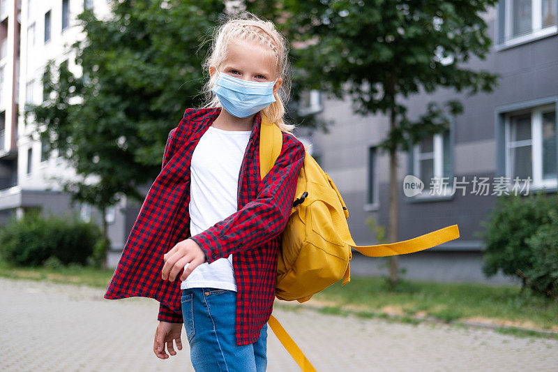 back to school. Girl wearing mask and backpacks protect and safety from coronavirus. Child going school after pandemic over. Looking at camera students are ready for new school year